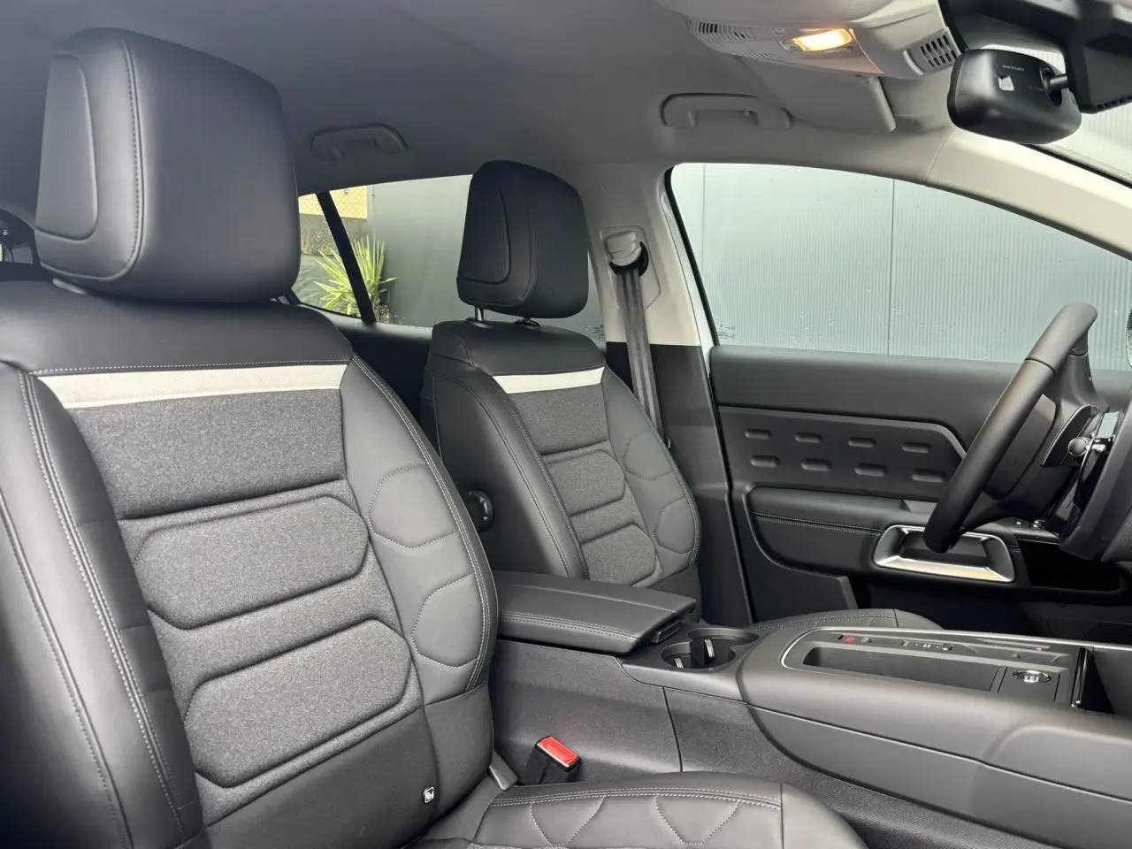 Vue intérieure côté conducteur et passager avant du Citroën C5 Aircross 2025 avec sièges Advanced Comfort en cuir et tissu gris.