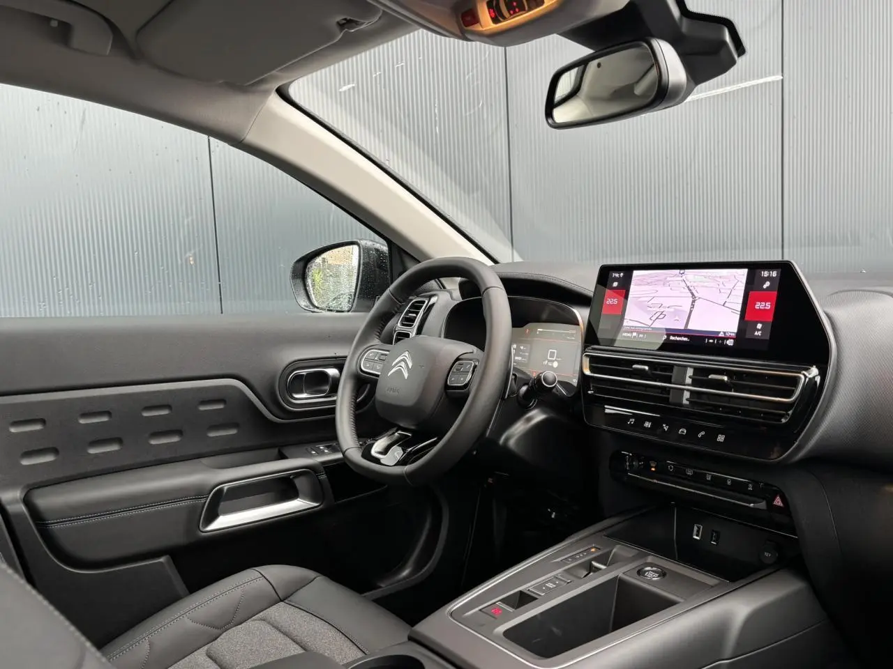 Intérieur noir du Citroën C5 Aircross 2025 vu côté conducteur, avec volant multifonction et écran tactile central.