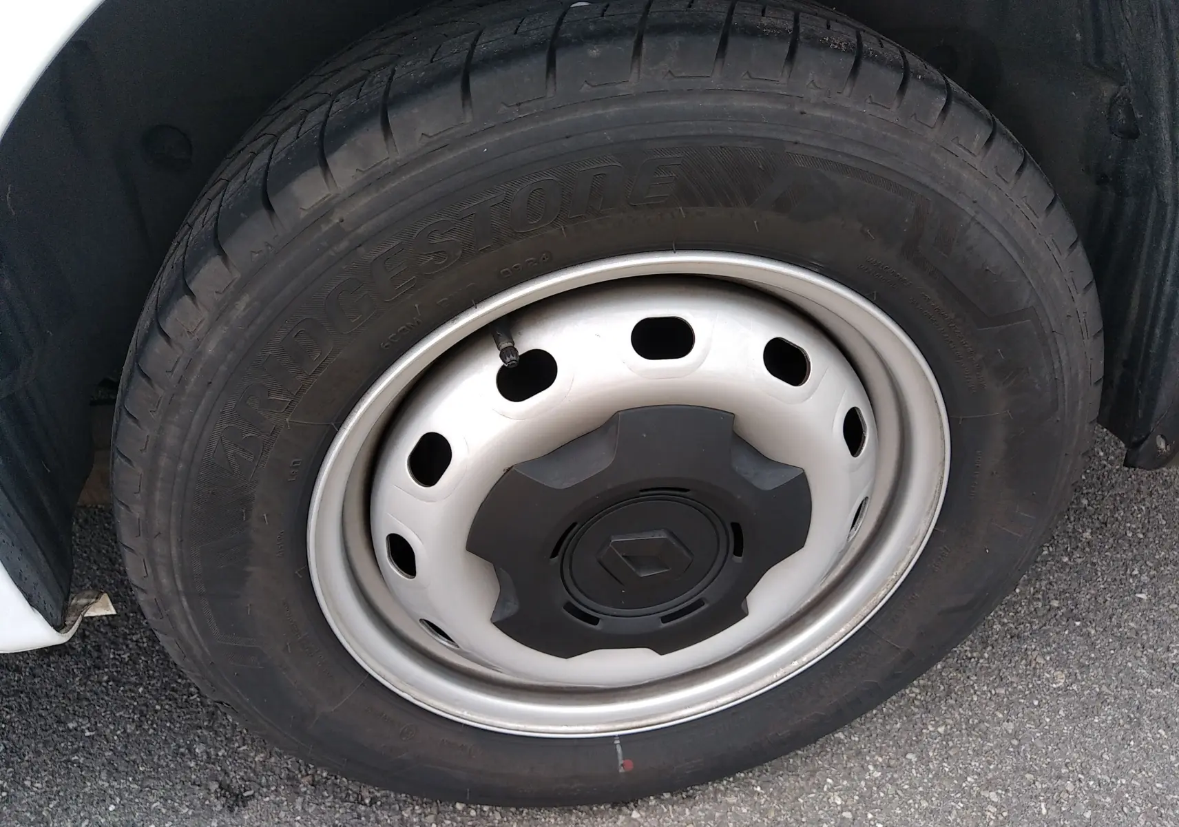 Gros plan sur la roue avant gauche du Renault Trafic Fourgon blanc, avec jante acier et logo Renault central.