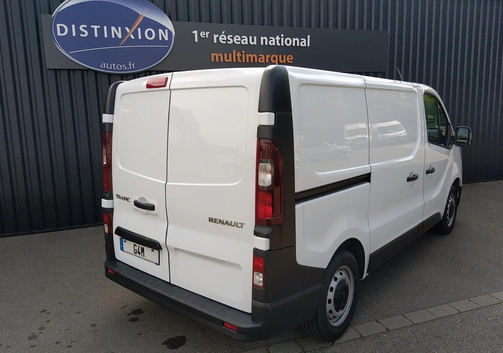 Renault Trafic Fourgon blanc en 3/4 arrière droit, avec portes arrière fermées et jantes acier noires.