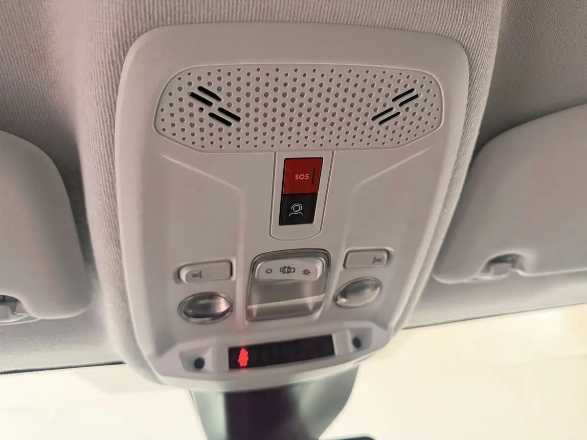 Plafonnier intérieur blanc avec boutons SOS et éclairage, vue en contre-plongée dans une Peugeot 208 blanche.
