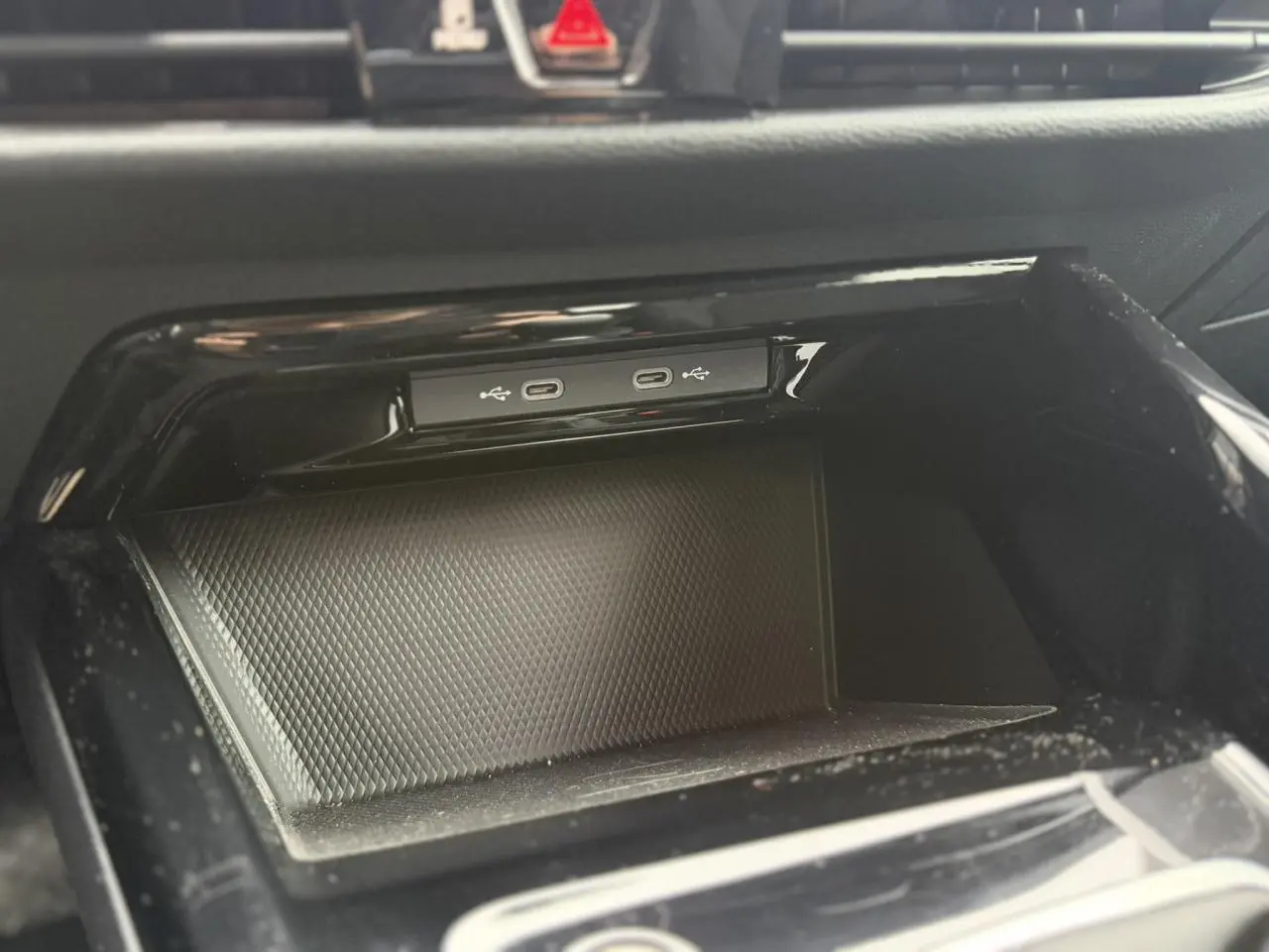 Gros plan sur la console centrale noire du Volkswagen Golf VIII avec deux ports USB-C intégrés.