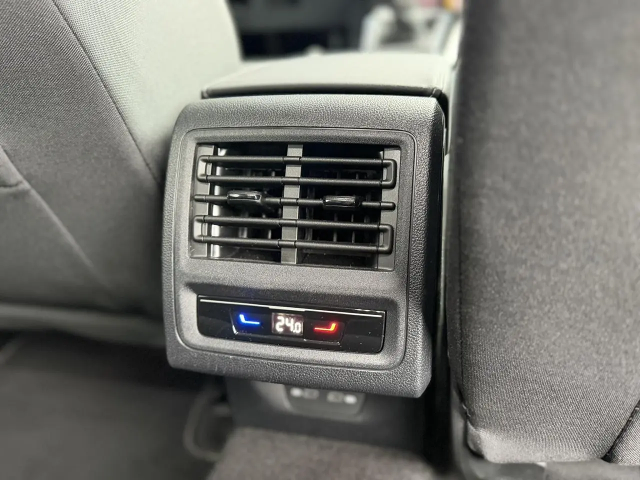 Gros plan sur la sortie d’air arrière avec réglage de température à 24°C dans l’habitacle noir d’une Volkswagen Golf VIII.