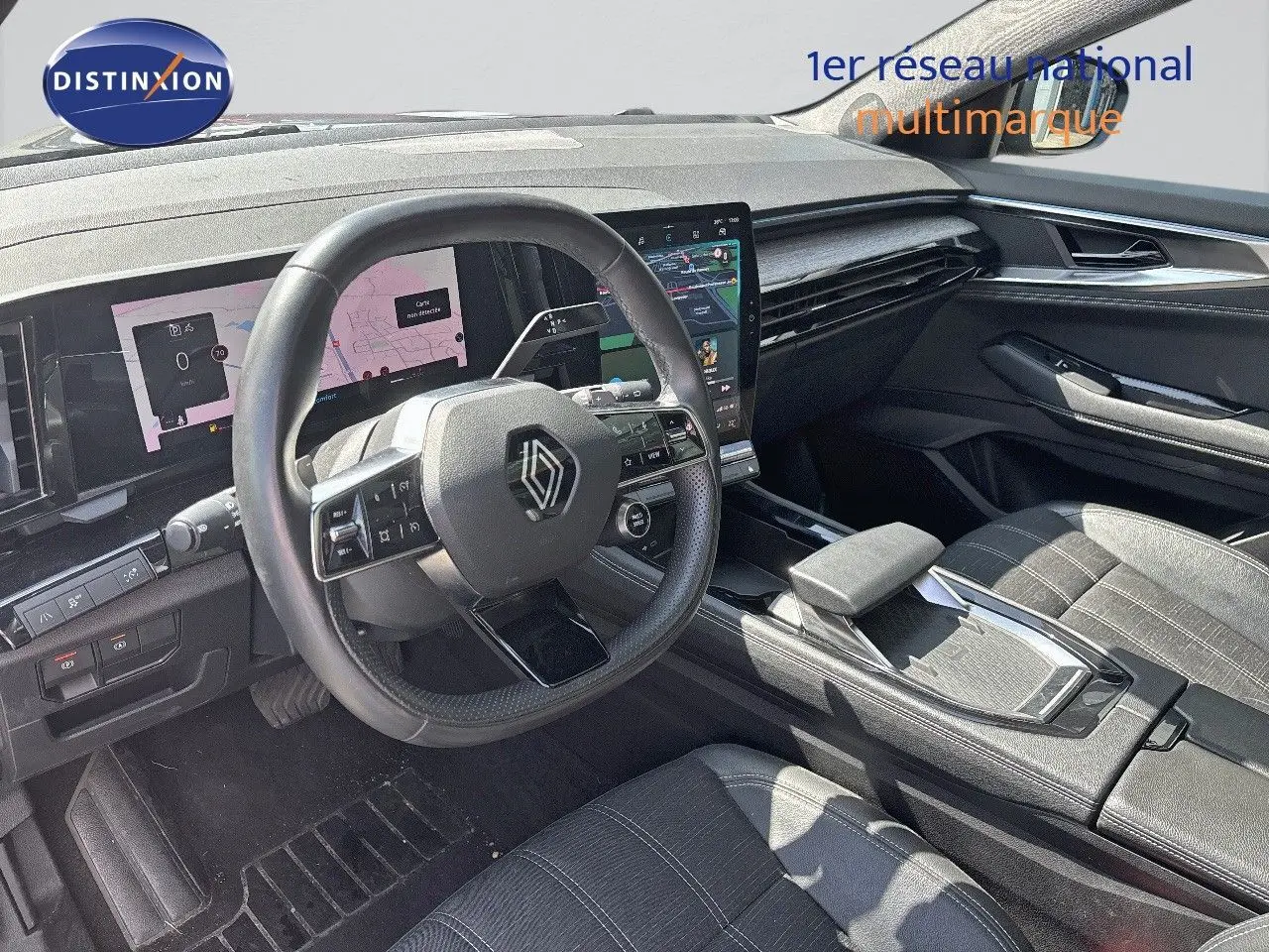 Vue intérieure côté conducteur du Renault Austral 2024, tableau de bord numérique et volant multifonction en cuir noir.
