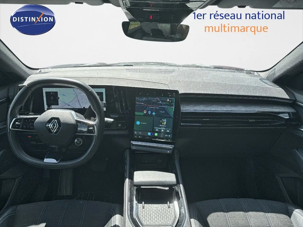 Vue intérieure avant du Renault Austral 2024, tableau de bord moderne avec écran tactile central et volant multifonction noir.