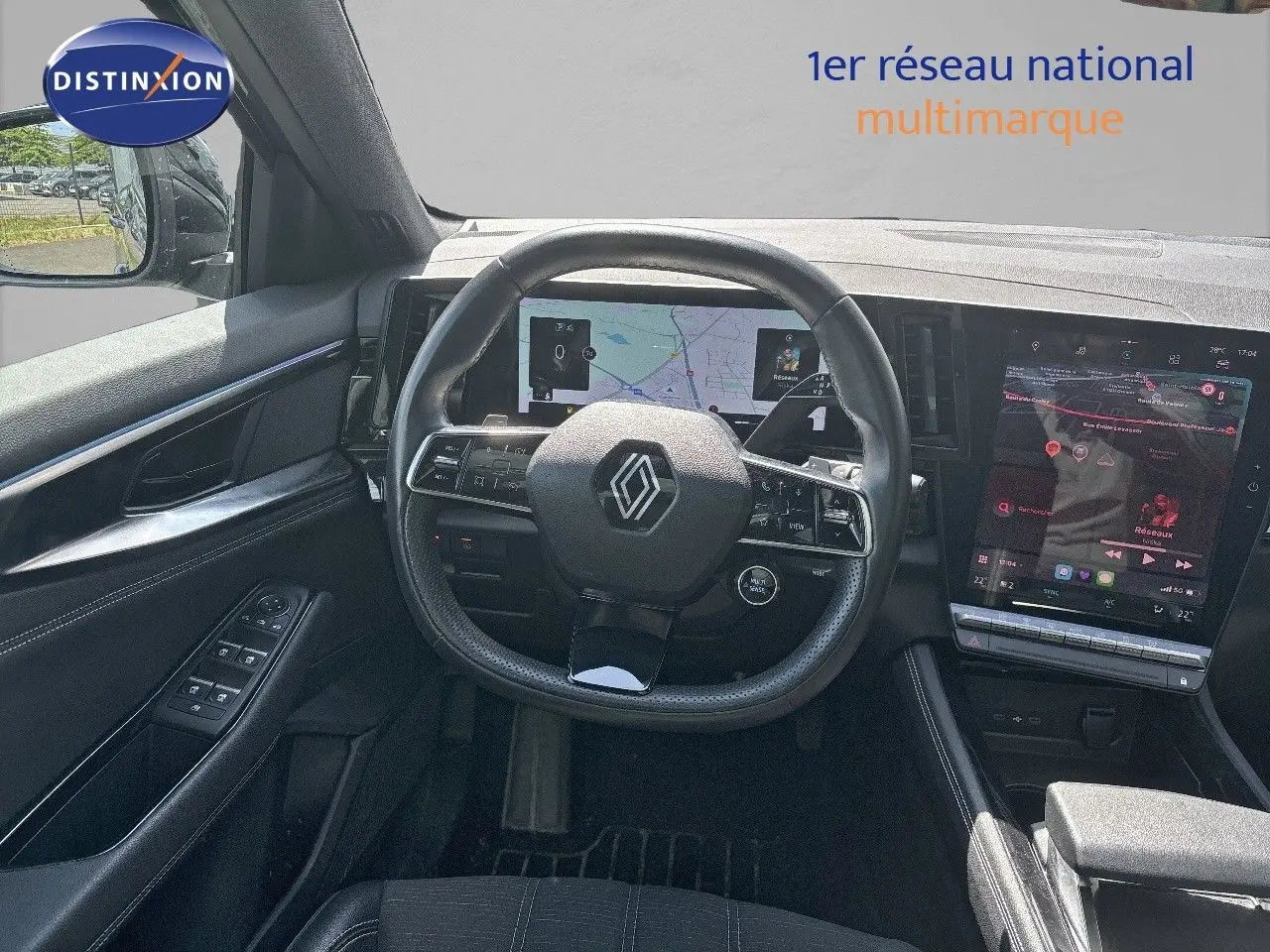 Vue intérieure centrée sur le volant et le tableau de bord digital du Renault Austral gris schiste métal, avec écran tactile vertical.