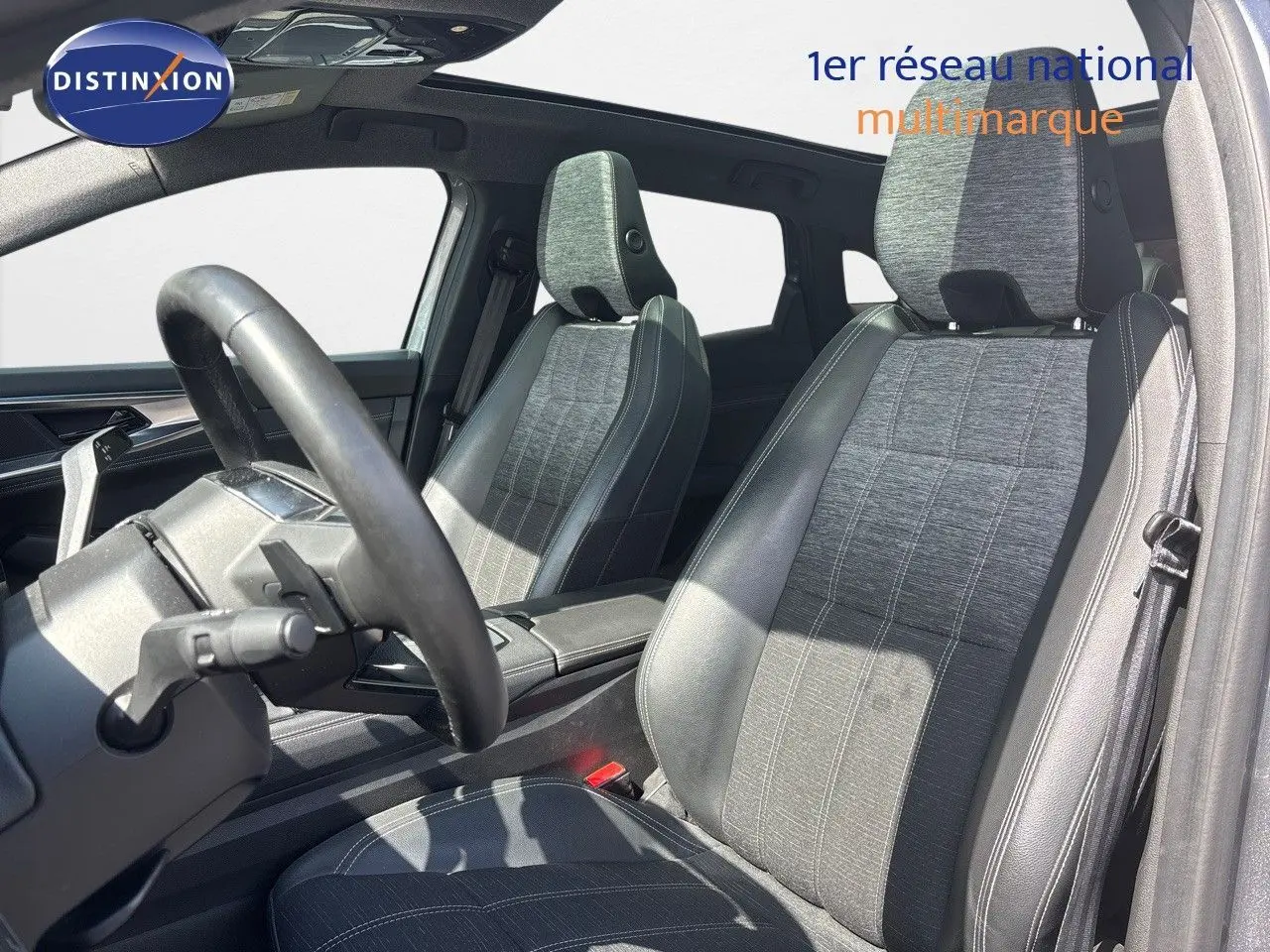 Vue intérieure des sièges avant en tissu gris et cuir noir du Renault Austral 2024, avec volant partiellement visible.