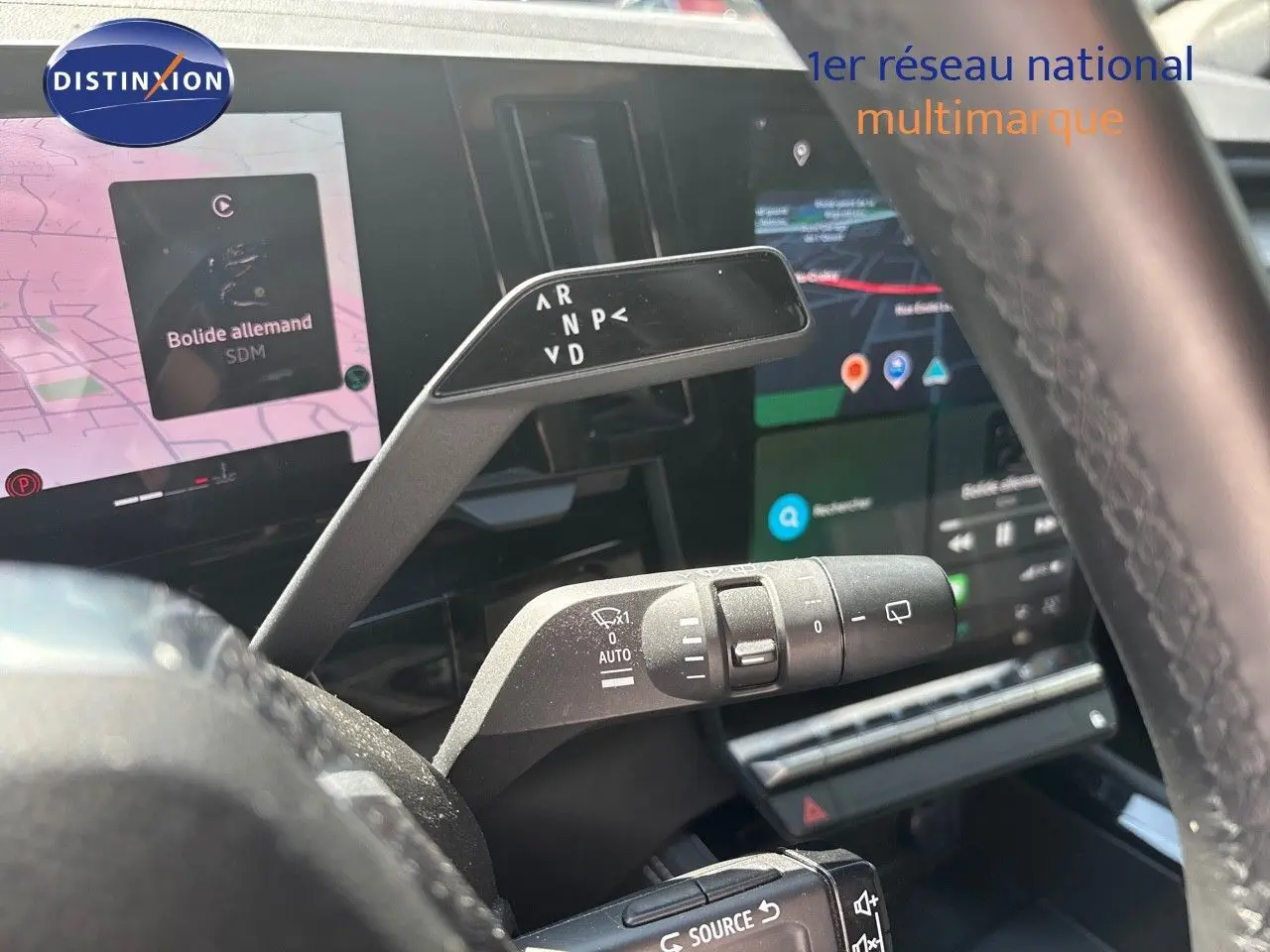 Vue rapprochée du levier de vitesses automatique et des commandes au volant d’un Renault Austral gris schiste métal 2024.