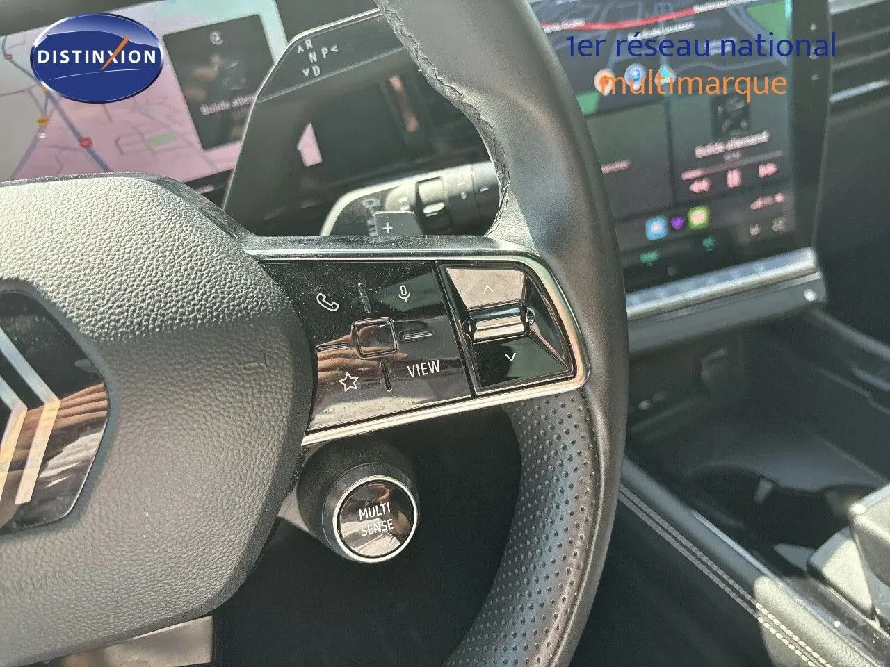 Gros plan sur le volant noir perforé du Renault Austral 2024 avec commandes intégrées et bouton Multi-Sense visible.