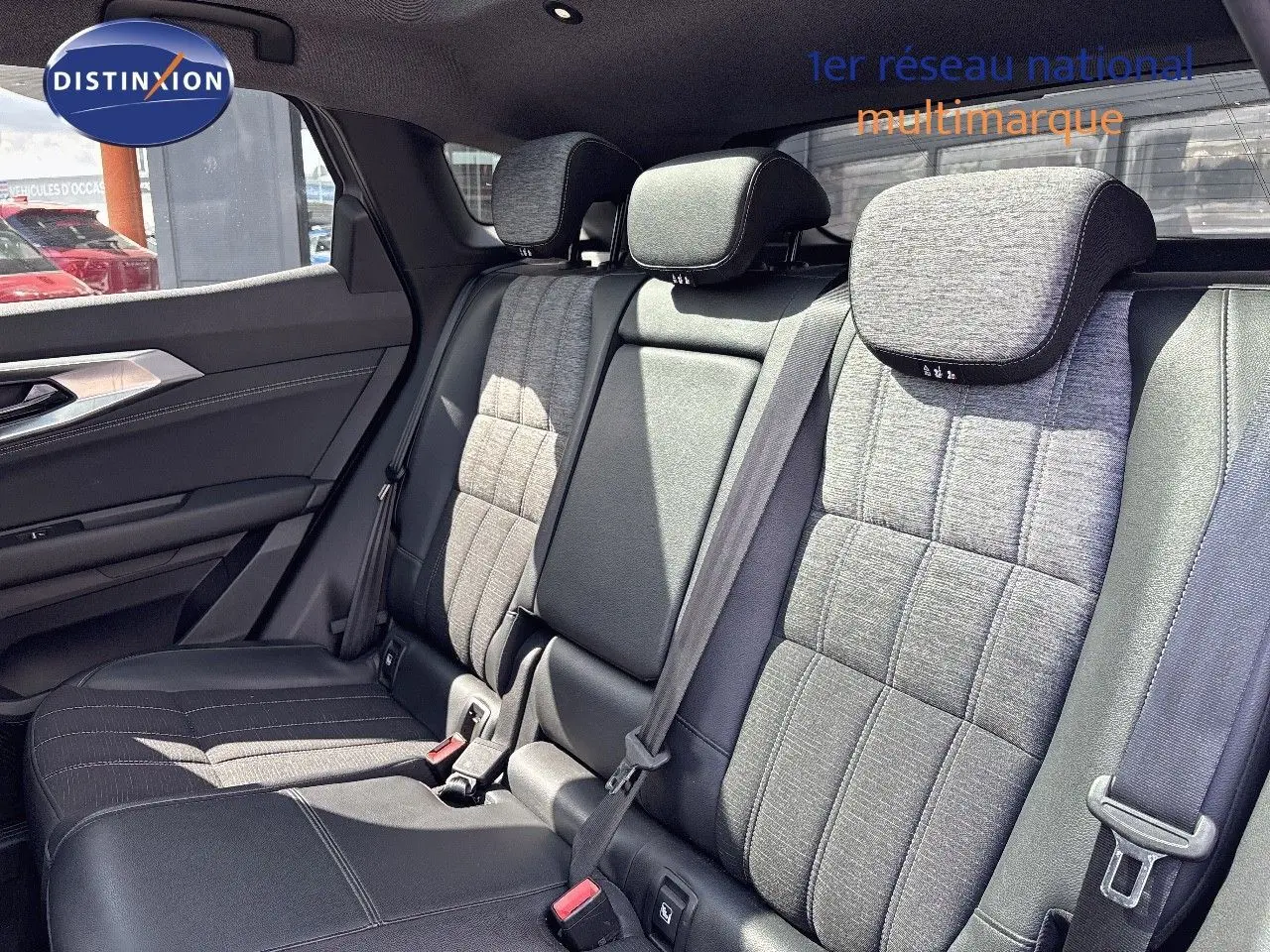 Vue intérieure des sièges arrière du Renault Austral 2024, tissu gris clair avec détails en cuir noir et ceintures de sécurité.