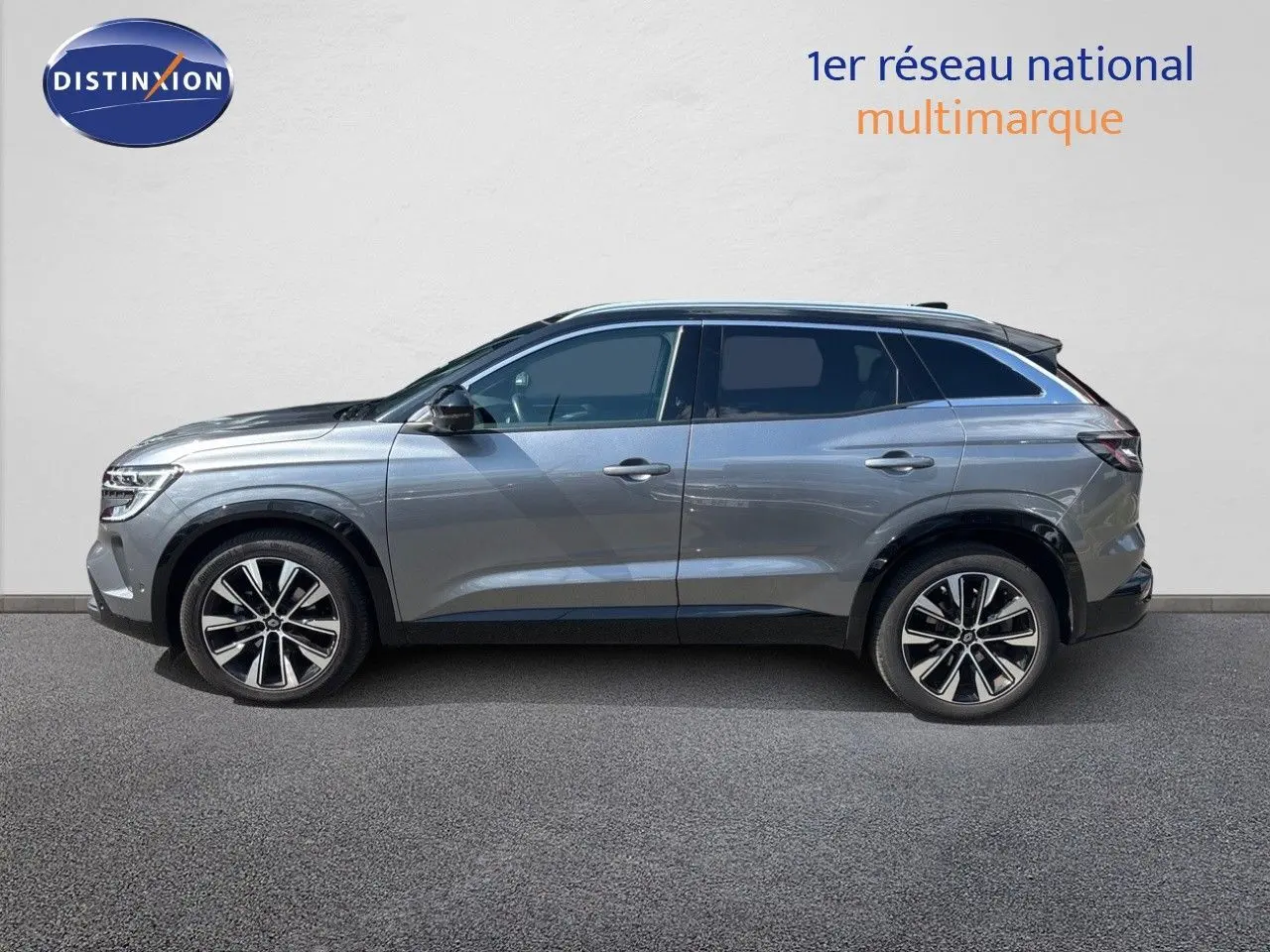 Profil droit d'un Renault Austral gris schiste métal 2024, SUV hybride avec jantes alliage bicolores et toit noir.