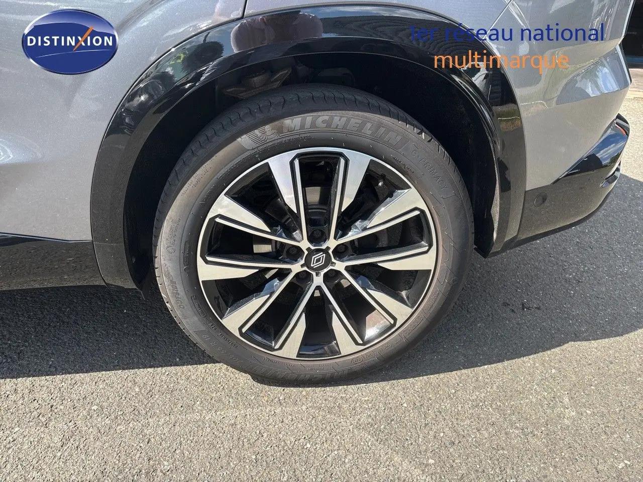 Gros plan sur la roue avant droite du Renault Austral gris schiste métal, mettant en valeur la jante alliage bicolore et le pneu Michelin.
