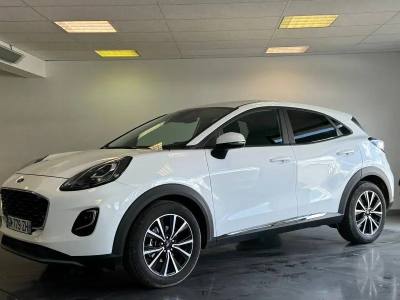 Vue 3/4 avant droite d'un Ford Puma blanc Glacier avec jantes noires et vitres arrière surteintées.