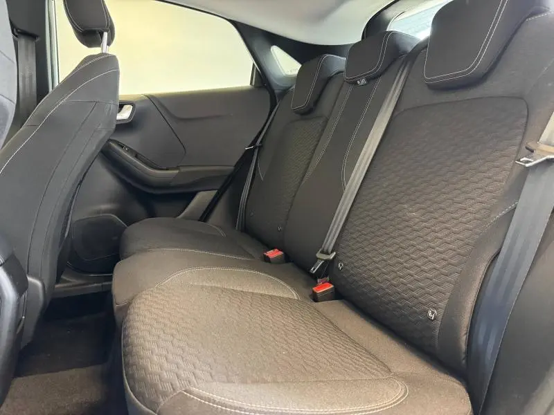 Vue intérieure côté droit des sièges arrière noirs avec surpiqûres blanches du Ford Puma 2023 blanc Glacier.