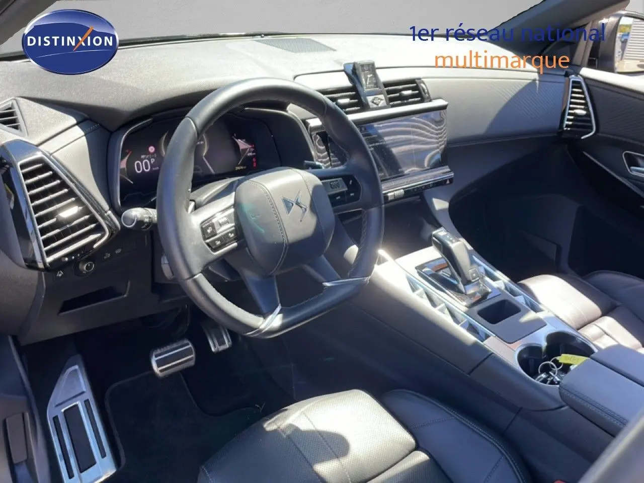 Vue intérieure côté conducteur du DS7 2024 noir métal, mettant en valeur le volant cuir et la console centrale moderne.