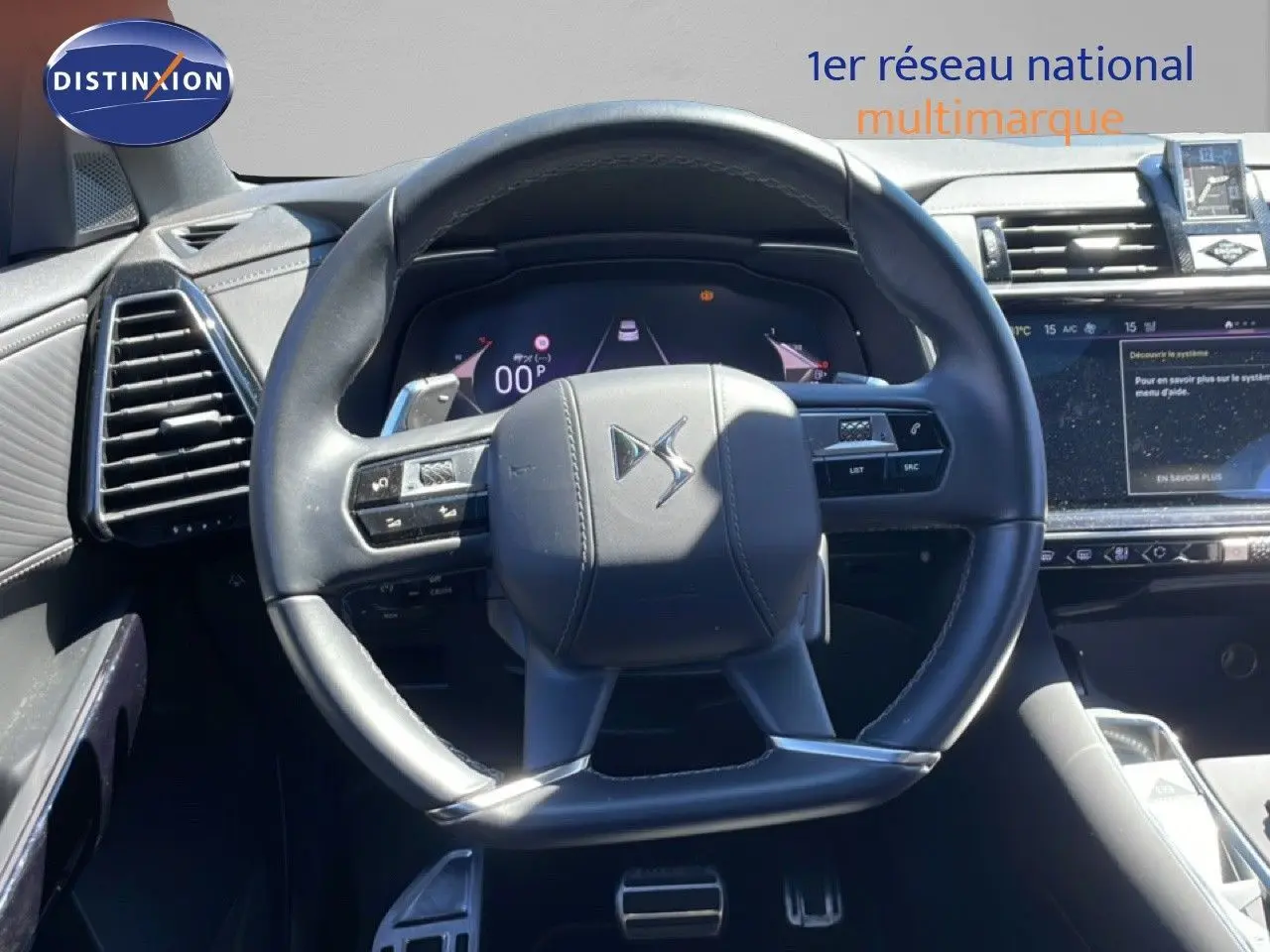 Vue rapprochée du volant DS noir cuir du DS7 2024, avec tableau de bord numérique et écran tactile visible à droite.