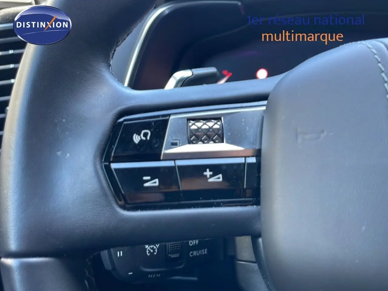 Gros plan sur le volant noir du DS7 2024, montrant les commandes audio et de régulateur de vitesse.