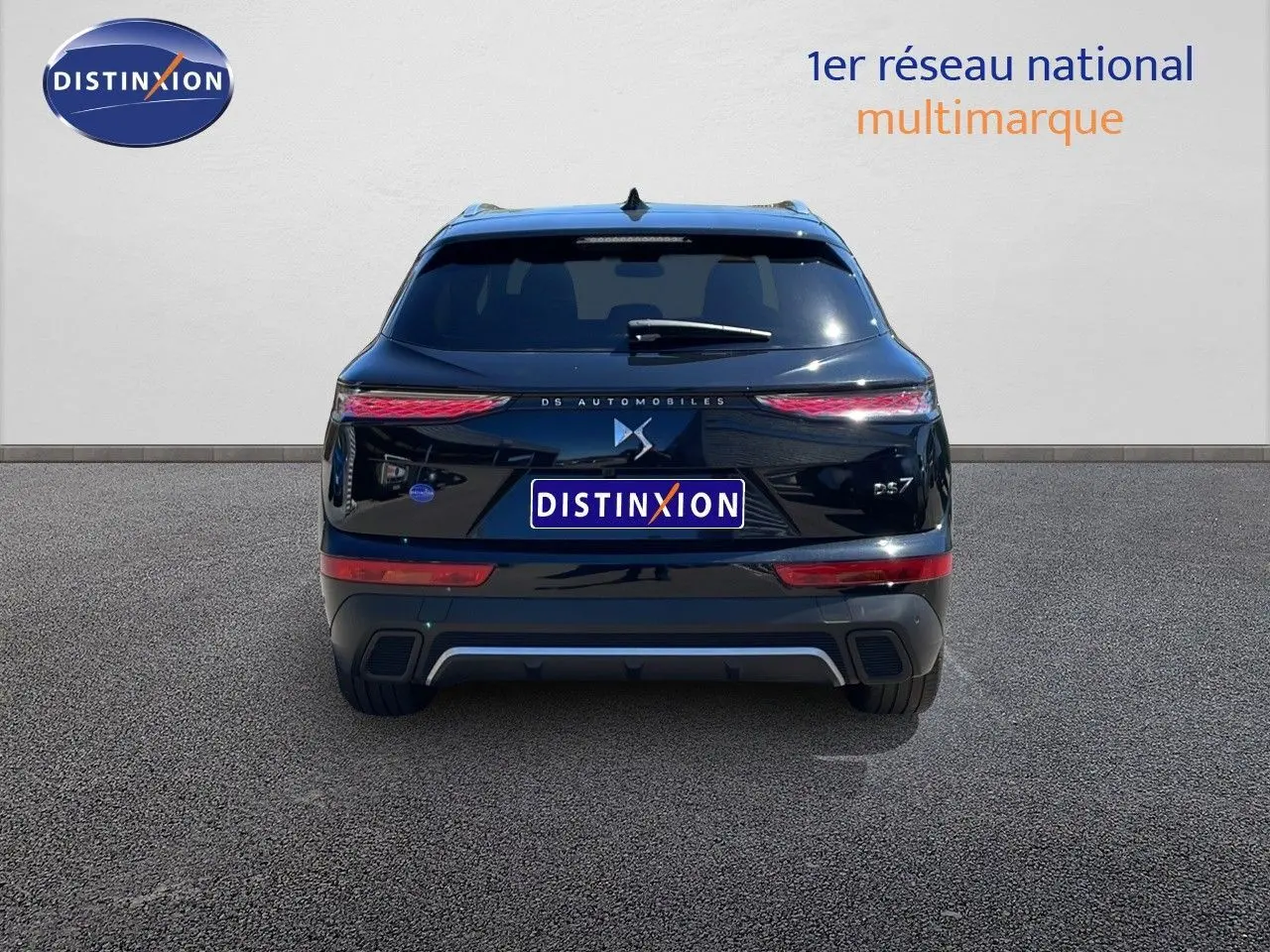 Vue arrière d'une DS7 noire métal 2024 avec feux LED effilés et logo DS centré sur un fond clair.