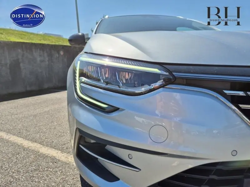 Gros plan sur le phare avant gauche du Renault Mégane Break gris Titanium 2024 avec feux LED et capteurs de stationnement.