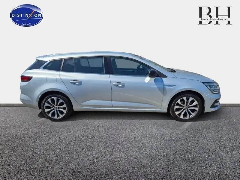 Profil droit d'une Renault Mégane Break 2024 gris titanium avec jantes alliage et vitres teintées.