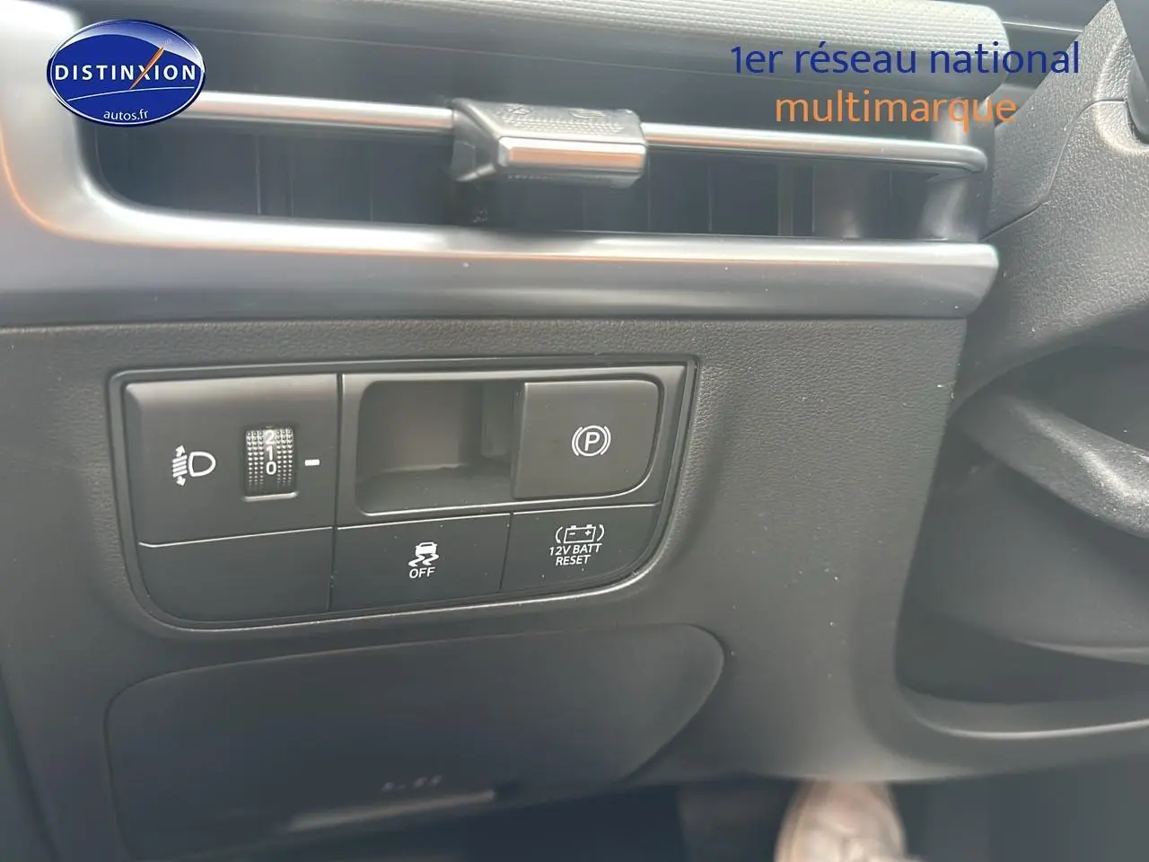 Détail du tableau de bord côté gauche du Hyundai Tucson blanc Sérénité 2025 avec commandes d'éclairage et frein de parking électrique.