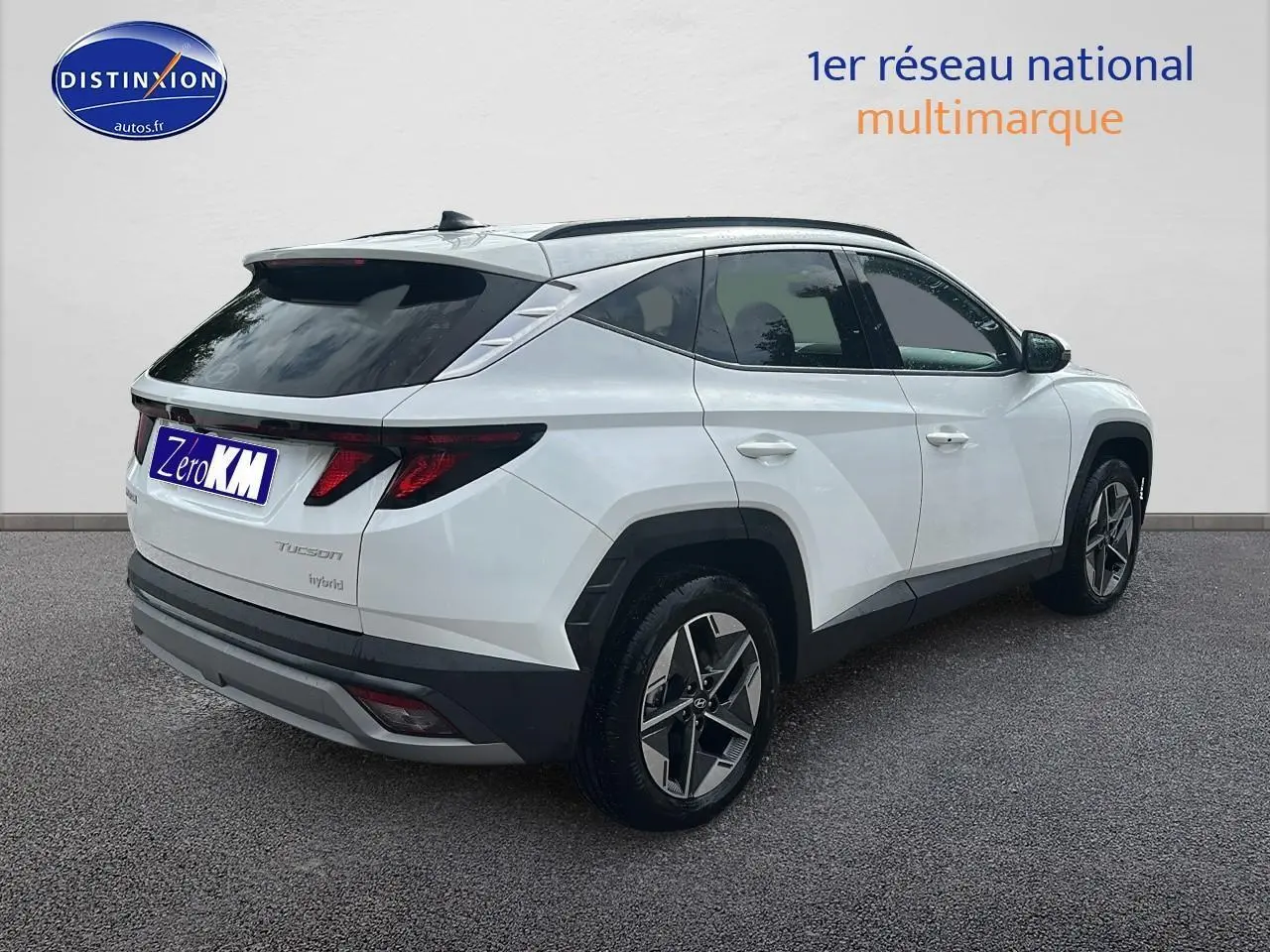 Vue 3/4 arrière droite d'un Hyundai Tucson blanc sérénité avec jantes alliage et vitres teintées.