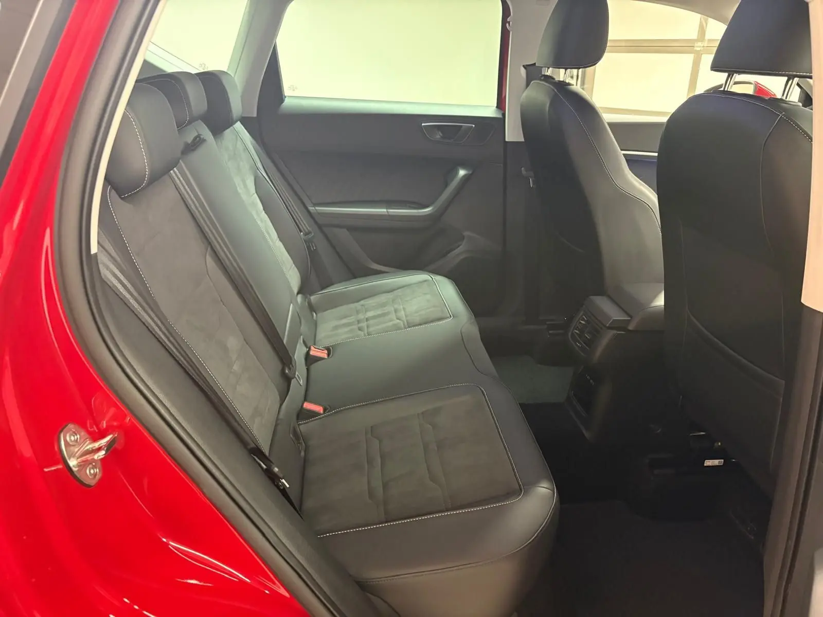 Vue intérieure côté gauche sur la banquette arrière noire avec surpiqûres, dans un SEAT Ateca Rouge Velvet 2024.