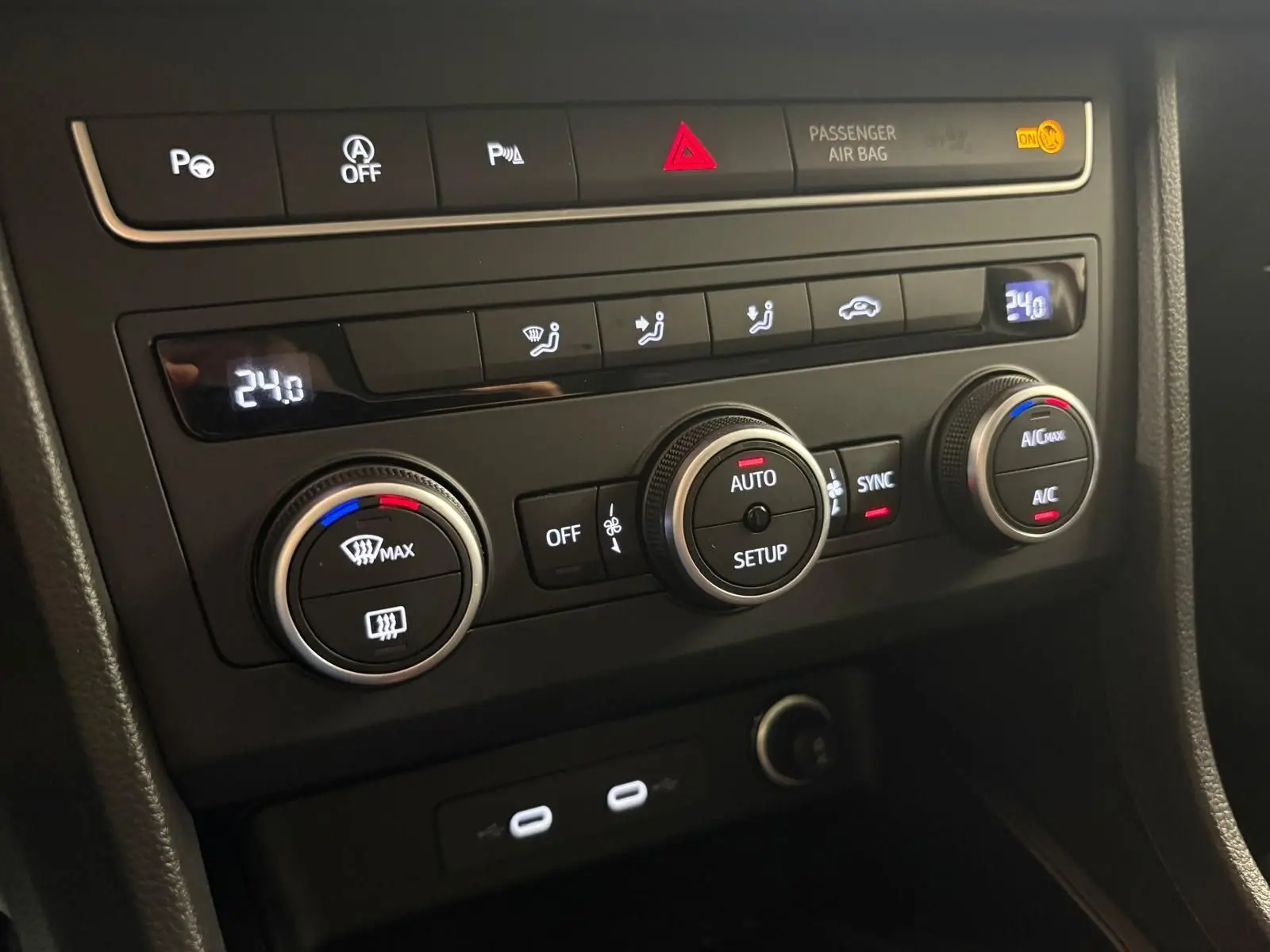 Vue rapprochée du tableau de bord du SEAT Ateca 2024, avec commandes de climatisation digitale et boutons fonctionnels.