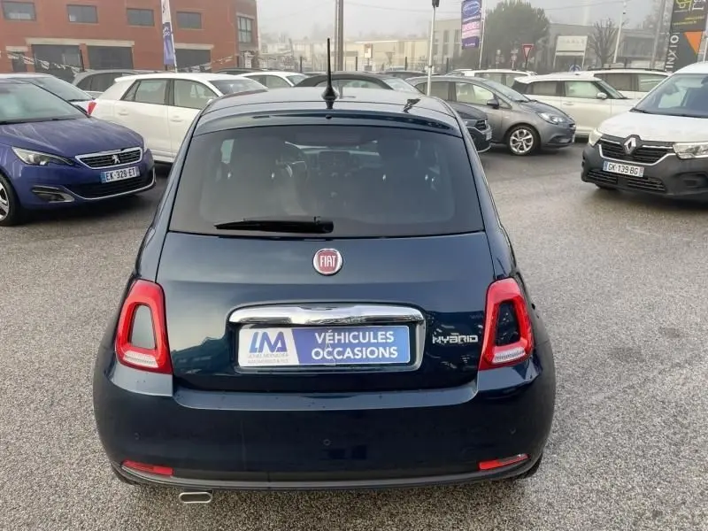 Vue arrière d'une FIAT 500 bleu métal 2023 avec logo Hybrid et plaque d'occasion sur un parking extérieur.