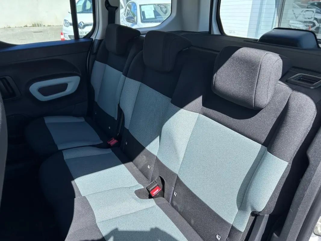Vue intérieure du siège arrière en tissu bicolore gris et noir du Citroën Berlingo blanc, côté droit ouvert.