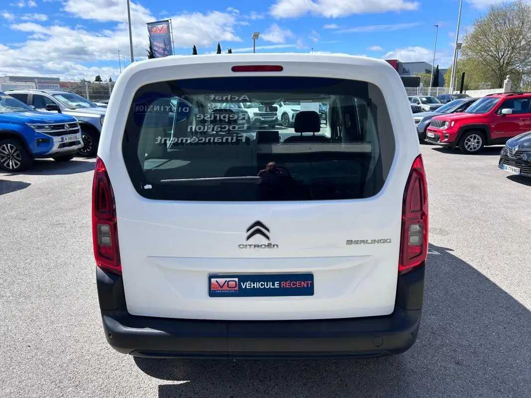 Vue arrière d'un Citroën Berlingo blanc 2020 avec hayon vitré et feux arrière verticaux, stationné en extérieur.