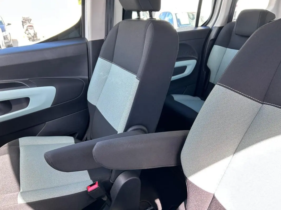 Vue intérieure côté droit montrant les sièges avant bi-ton gris et noir avec accoudoir du Citroën Berlingo blanc.