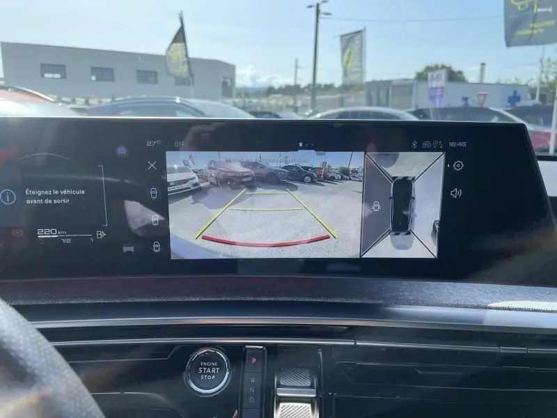 Vue intérieure du tableau de bord du Peugeot 3008 2024, écran affichant la caméra de recul et l'interface de stationnement.