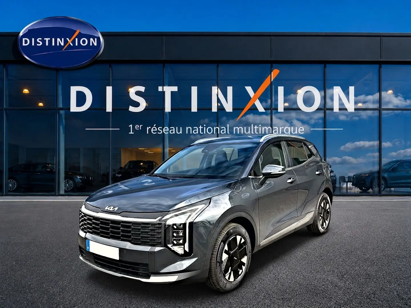 KIA Sportage 1.6 hybride gris eclipse en 3/4 avant droit, avec calandre noire et jantes alu distinctives.