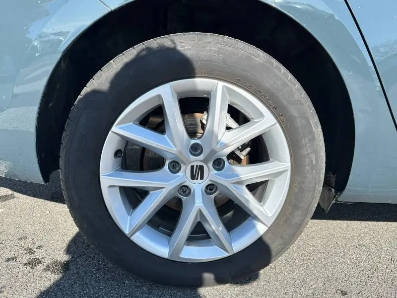 Gros plan sur la roue avant gauche d'une SEAT LEON ST Bleu Saphir Métallisée avec jante alliage à 5 doubles branches.