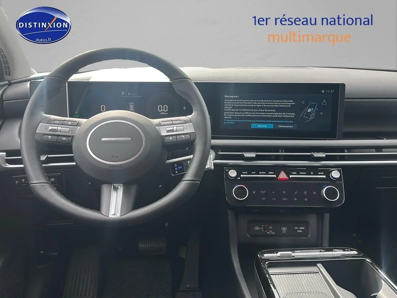 Vue intérieure du tableau de bord et volant cuir noir du Hyundai Tucson 2025 hybride, avec écran tactile large et commandes intégrées.