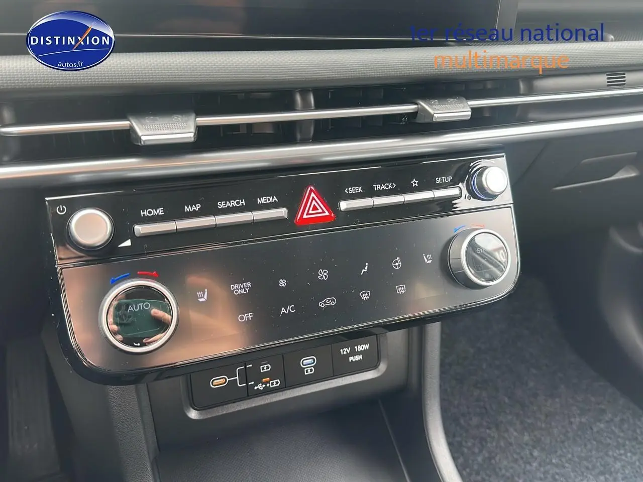 Vue rapprochée de la console centrale du Hyundai Tucson 2025 avec commandes climatisation et connectiques USB visibles.