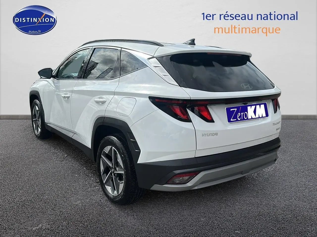 Vue 3/4 arrière droite du Hyundai Tucson blanc sérénité avec jantes alliage et vitres teintées.