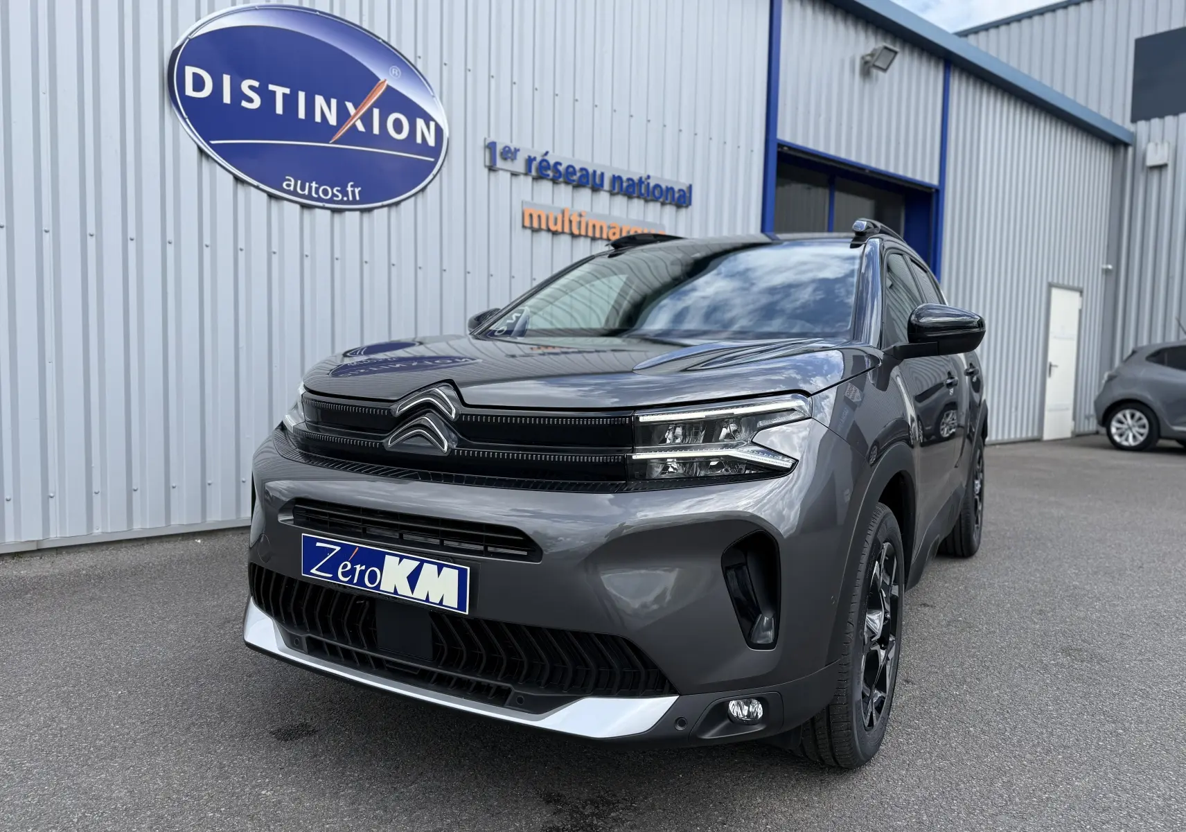 Citroën C5 Aircross gris platinium métal en 3/4 avant droit, avec calandre noire et jantes noires distinctives.