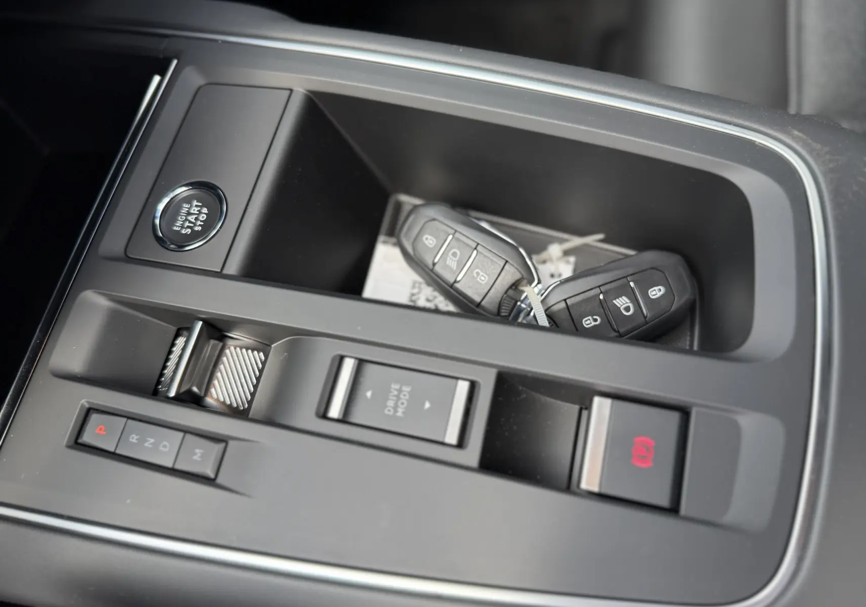 Gros plan sur la console centrale noire du Citroën C5 Aircross avec clés, bouton start et commandes de boîte auto.