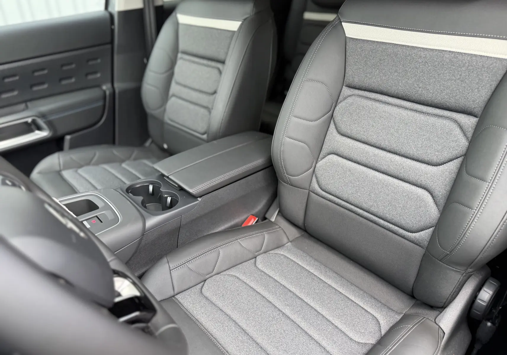 Vue intérieure rapprochée des sièges avant gris clair et foncé en tissu et cuir du Citroën C5 Aircross 2025.