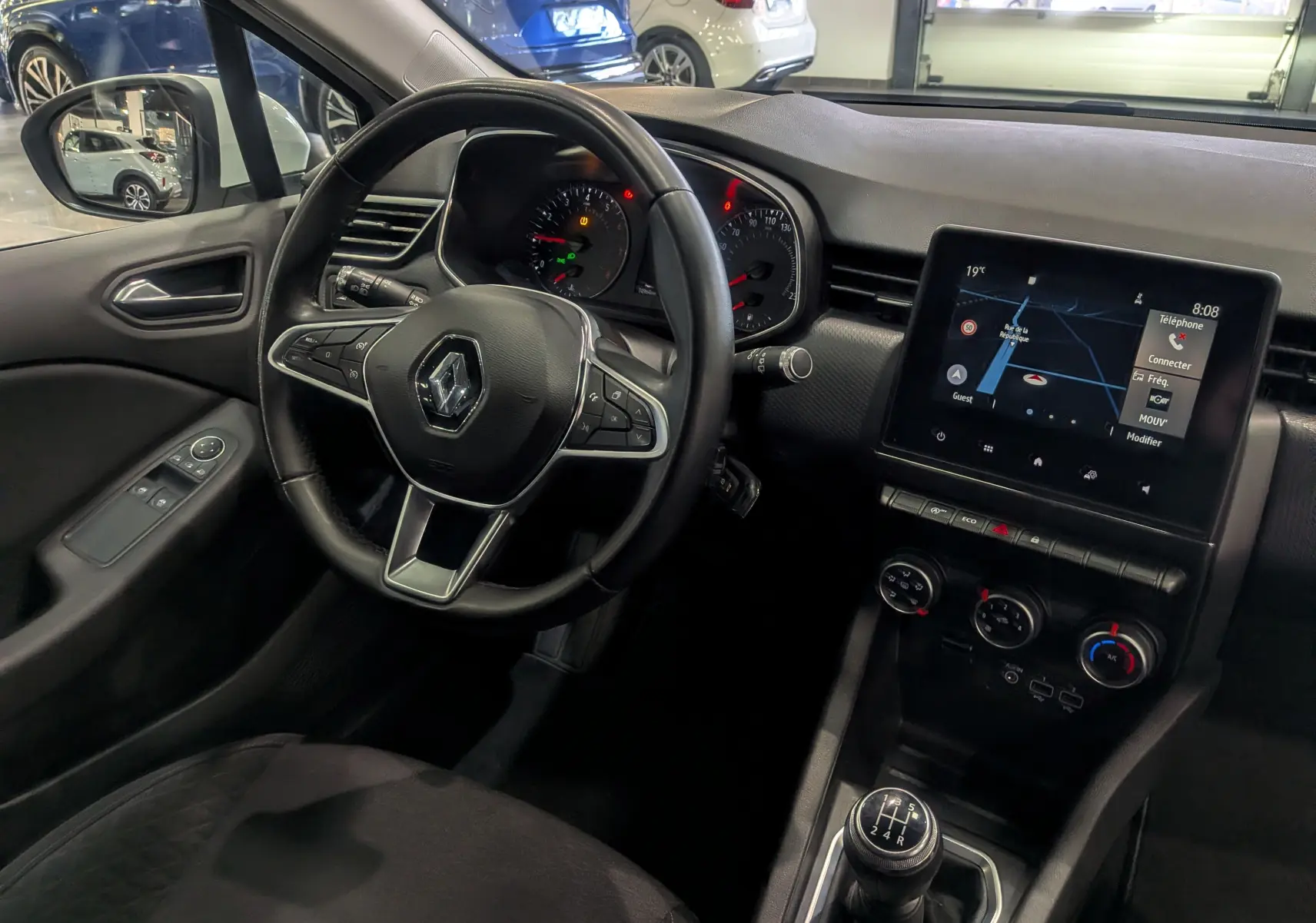 Vue intérieure côté conducteur de la Renault Clio V TCe 100 Business 2020 avec écran tactile et levier de vitesses manuel.