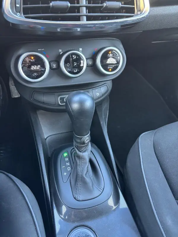 Vue rapprochée de la console centrale du Fiat 500X gris MY23, montrant la boîte auto et les commandes de climatisation manuelle.