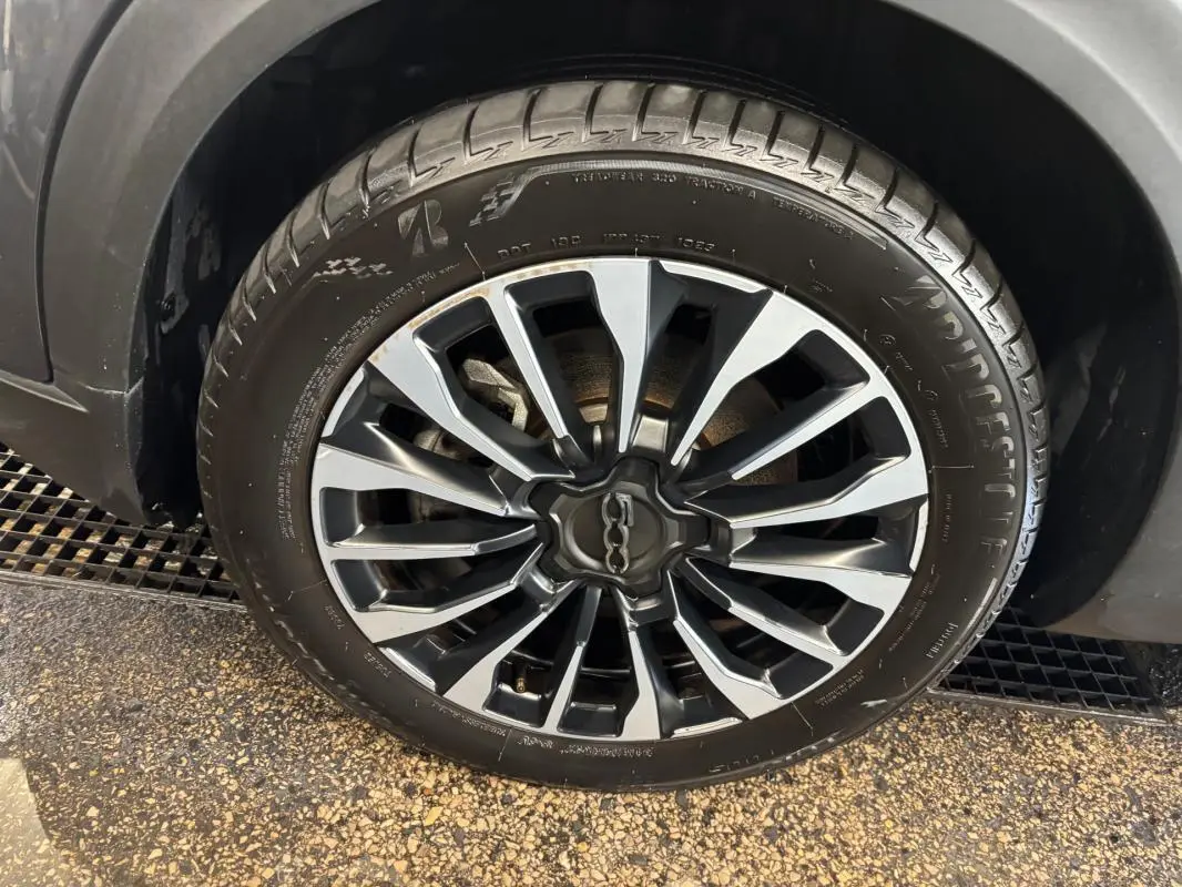 Gros plan sur la jante 16 pouces classique gris et noir de la FIAT 500X MY23, avec pneu Bridgestone visible.
