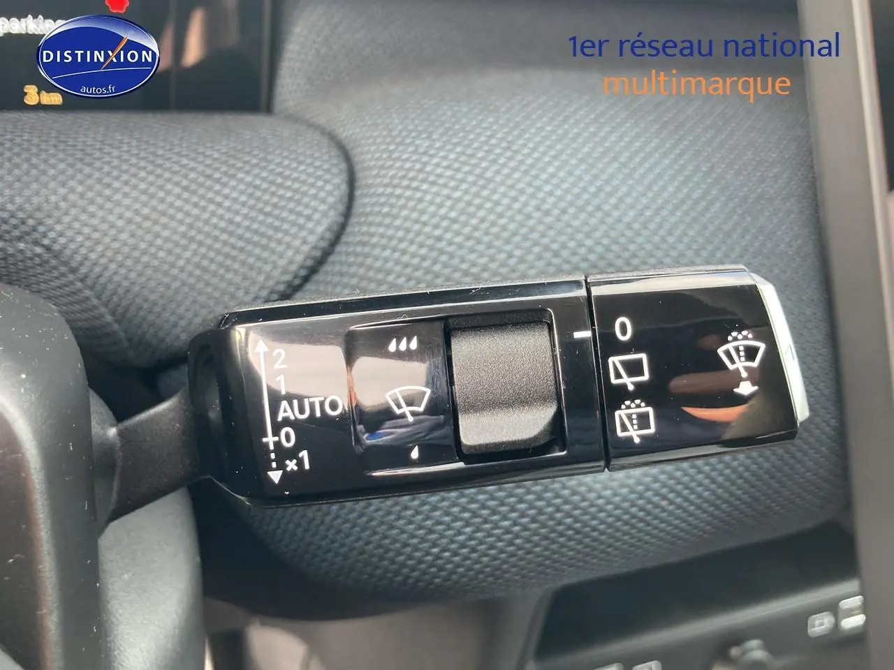 Gros plan sur la commande des essuie-glaces dans l’habitacle d’un Citroën C5 Aircross noir, détail du bouton et symboles blancs.