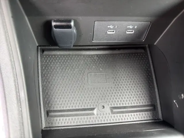 Gros plan sur la zone de recharge sans fil et ports USB-C noirs dans l’habitacle du Renault Symbioz noir 2025.