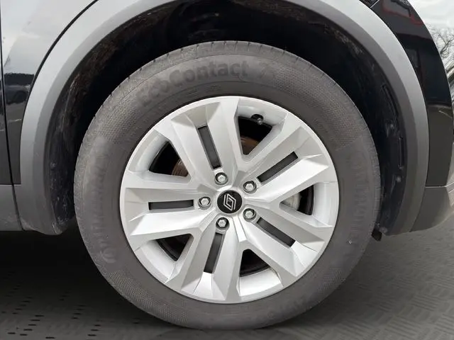 Gros plan sur la roue avant gauche noire du Renault Symbioz E-Tech Full Hybrid 145 Evolution avec jante argentée à cinq branches.