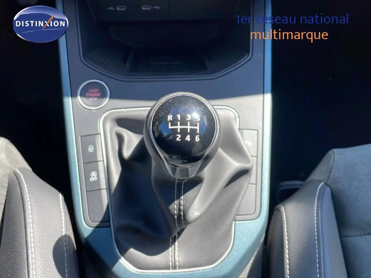 Gros plan sur le levier de vitesse manuel noir du SEAT Arona 2025, entouré de la console centrale bleu métallisé.