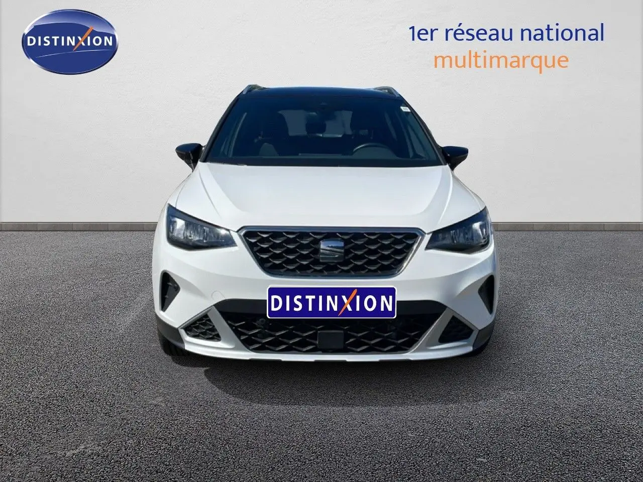 Vue avant d'un SEAT Arona 2025 blanc avec toit noir, calandre noire et phares LED, sur fond neutre.