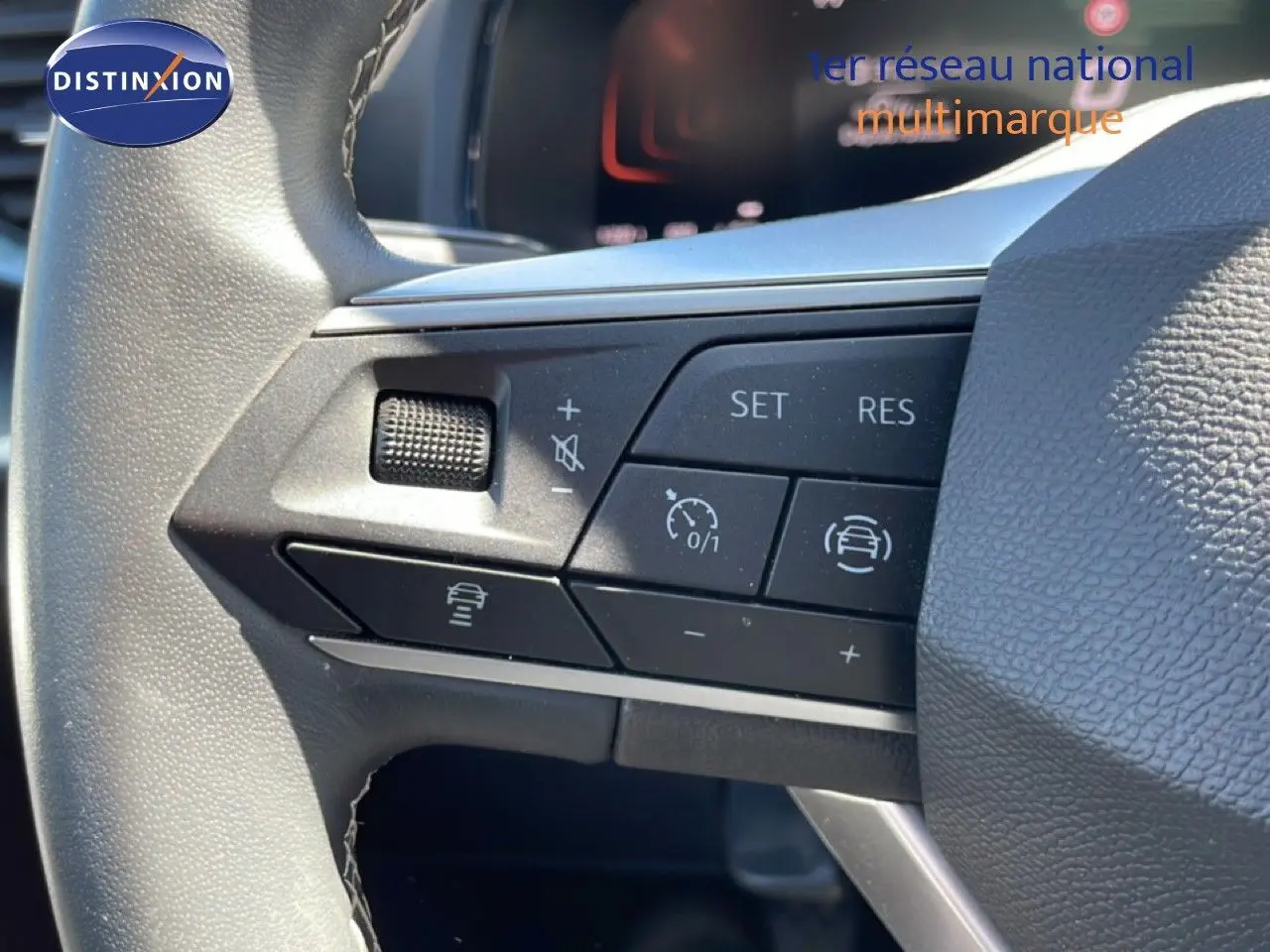 Gros plan sur les commandes de régulateur de vitesse au volant cuir noir d’un SEAT Arona 2025.